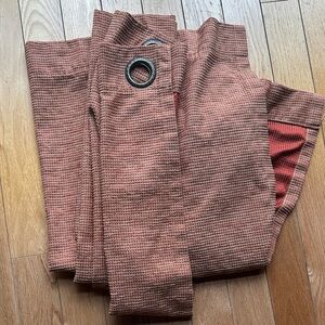 Two panels of textured burnt orange curtains